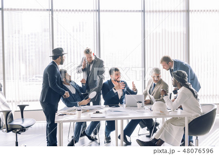 Serious male colleagues constructors checking sketch working in team cooperate Serious male colleagues constructors checking sketch working in team cooperate 48076596