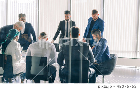 Multiracial male business executives discuss project sitting at conference table 48076765