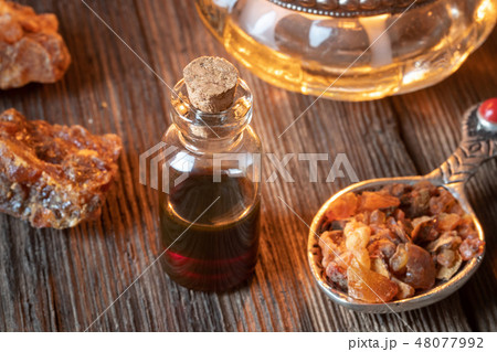 A bottle of myrrh essential oil with myrrh resin A bottle of myrrh essential oil with myrrh resin 48077992