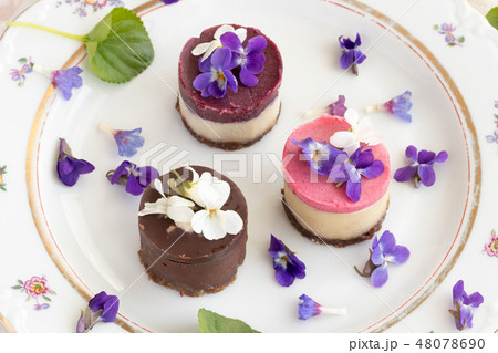 Raw vegan desserts on a plate with violet flowers 48078690