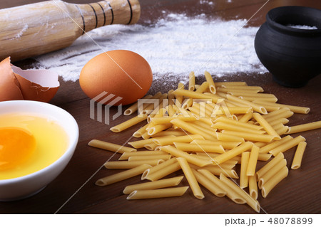 penne pasta bolognese, spaghetti ready for cooking on the background of egg, flour, salt etc 48078899
