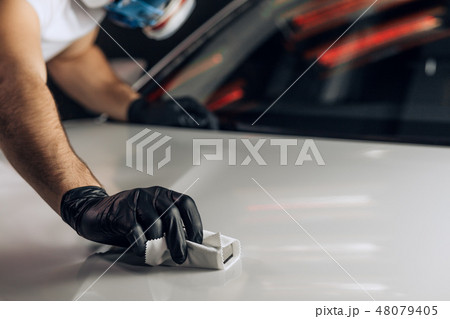 young mechanic in mask working carefully at the garage 48079405