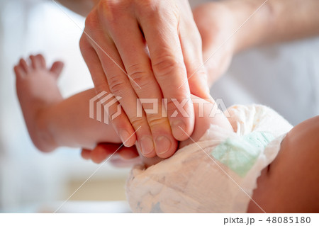 Photo of hands of massage therapist making foot massage to small child/ 48085180