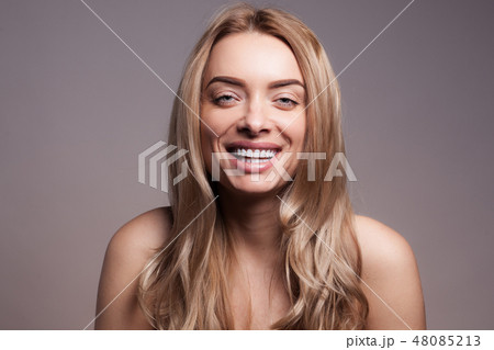 Adult beautiful blond woman with white veneers on the teeth. Adult beautiful blond woman with white veneers on the teeth. 48085213