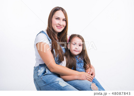 Family, children and parenthood concept - Young woman with her little cute child on white background Family, children and parenthood concept - Young woman with her little cute child on white background 48087843