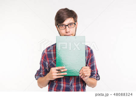 Education, student and business people concept - young man with file and pencil. Guy is shy and Education, student and business people concept - young man with file and pencil. Guy is shy and 48088324