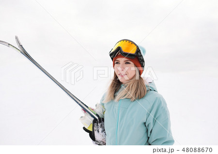 A beautiful young girl in an extreme sports suit, a hat and a helmet with a mask on the winter slope A beautiful young girl in an extreme sports suit, a hat and a helmet with a mask on the winter slope 48088670