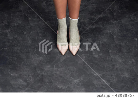 Slim legs of a woman in studio on black background Slim legs of a woman in studio on black background 48088757