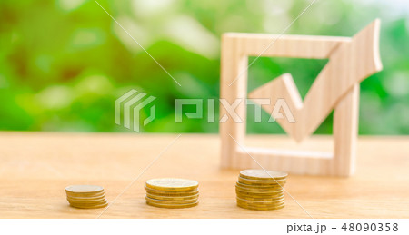 Wooden check mark and stacks of coins Wooden check mark and stacks of coins 48090358