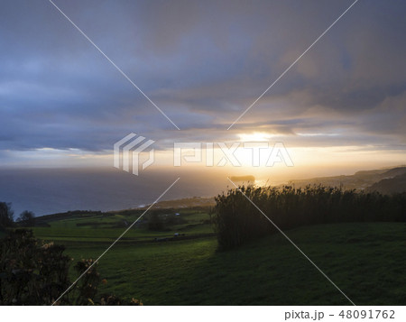 Aerial view of Vila Franca do Campo town volcanic islet during orange sunset with clouds, contre Aerial view of Vila Franca do Campo town volcanic islet during orange sunset with clouds, contre 48091762