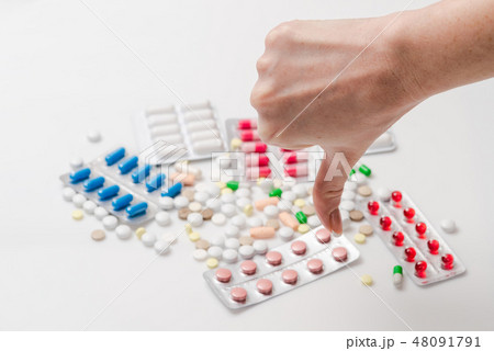 Female showing thumb down for medicine pills Female showing thumb down for medicine pills 48091791