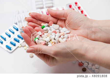 Handful full of pills of different colors Handful full of pills of different colors 48091808