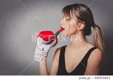 woman in boxing gloves with red lipstick in hands 48093803