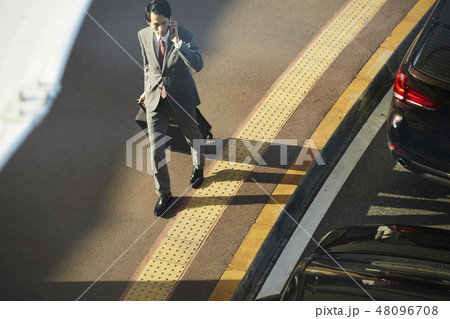 空港で電話をする海外出張のビジネスマン 空港で電話をする海外出張のビジネスマン 48096708