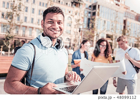 Positive delighted man using his laptop 48099112