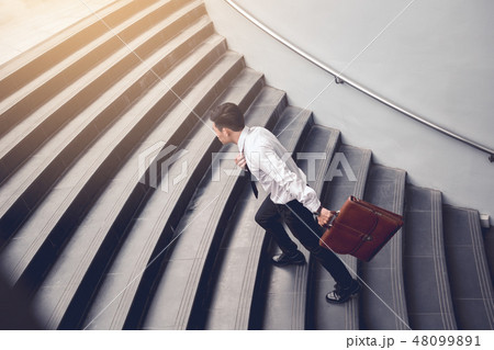 Businessman walking up on stairs Businessman walking up on stairs 48099891