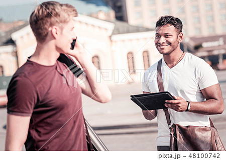 Delighted young man looking at his group mate Delighted young man looking at his group mate 48100742