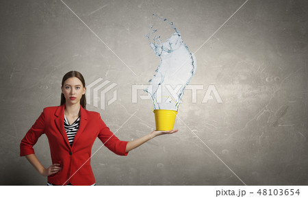 Girl pouring water from bucket 48103654
