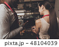Barista man and woman looking at a laptop 48104039