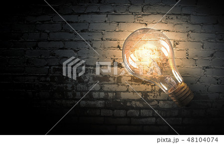 Light bulb on brick surface Light bulb on brick surface 48104074