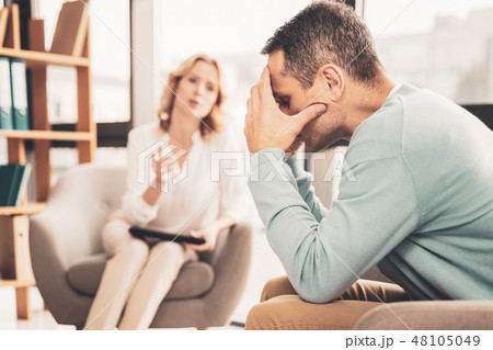 Stressed man feeling troubled speaking to therapist 48105049
