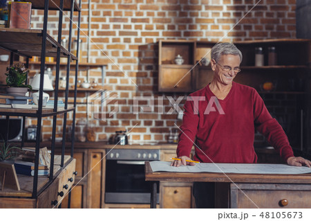 Cheerful aged architect smiling while working at the project 48105673