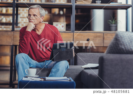 Serious pensioner putting his chin oh a fist while thinking 48105681