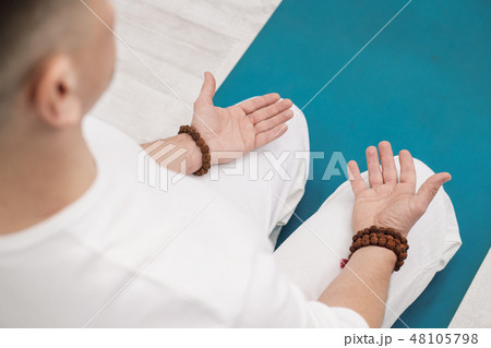 Concept of yoga and meditation. Close-up, hands of a man in white clothes, folded in prayer. White Concept of yoga and meditation. Close-up, hands of a man in white clothes, folded in prayer. White 48105798