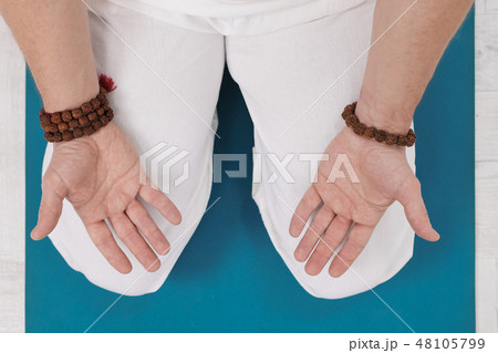 Concept of yoga and meditation. Close-up, hands of a man in white clothes, folded in prayer. White Concept of yoga and meditation. Close-up, hands of a man in white clothes, folded in prayer. White 48105799