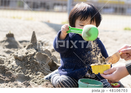 砂場で砂遊びする子供 48106703