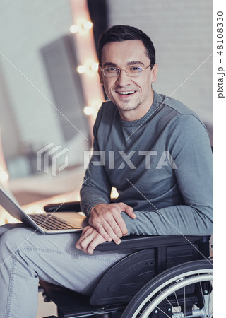 Happy disabled man sitting in front of his laptop Happy disabled man sitting in front of his laptop 48108330