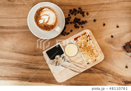 Apple crumble on wood tray with hot latte coffee Apple crumble on wood tray with hot latte coffee 48110761