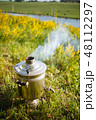 Golden samovar on the nature of the river smokes and heats water 48112297