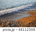 Sea waves on the coast of pebbles at sunrise 48112308