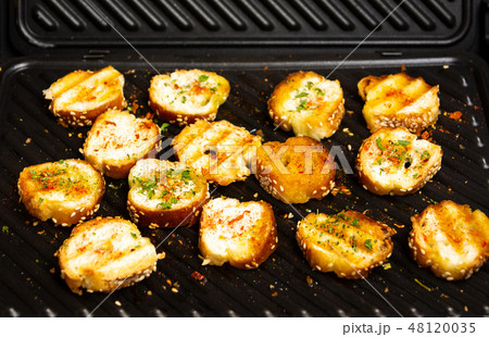 Slices of bread on a grill for making bruschetta Slices of bread on a grill for making bruschetta 48120035