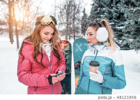 Two girls girlfriends beautiful women happy talking on background snowboarding. Resting resort, in 48121956