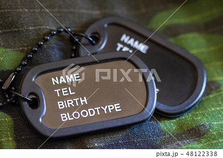 Soldier tag or dog tag laid on military jacket. 48122338