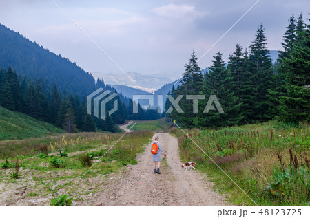Hiker and her dog in mountain landscape 48123725