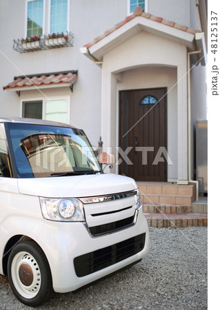 一戸建て 一軒家 外観 乗用車 軽自動車 外構 玄関 ドア 窓 二階建て 南欧風 門柱 瓦屋根 の写真素材