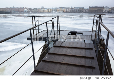 Wet wooden pier on Neva River Wet wooden pier on Neva River 48125452