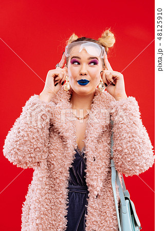 Millennial woman wearing pink fluffy coat and accessories Millennial woman wearing pink fluffy coat and accessories 48125910