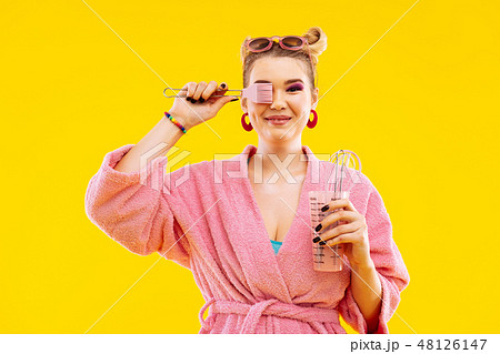 Housewife wearing bathrobe holding kitchen utensils before cooking Housewife wearing bathrobe holding kitchen utensils before cooking 48126147