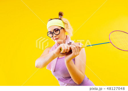 Blonde-haired woman wearing glasses holding tennis racket 48127048