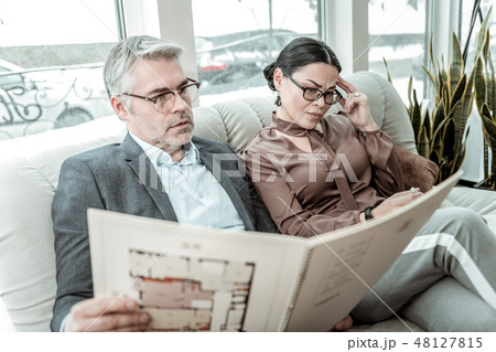 Brunette adult businesswoman in a brown satin blouse looking thoughtful Brunette adult businesswoman in a brown satin blouse looking thoughtful 48127815