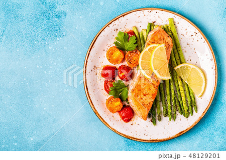 Grilled salmon with asparagus and tomatoes. 48129201