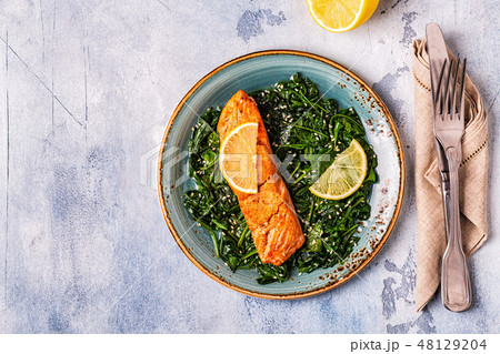 Grilled salmon with spinach. 48129204