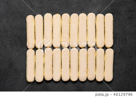 Italian Savoiardi ladyfingers Biscuits on dark concrete backgound Italian Savoiardi ladyfingers Biscuits on dark concrete backgound 48129796