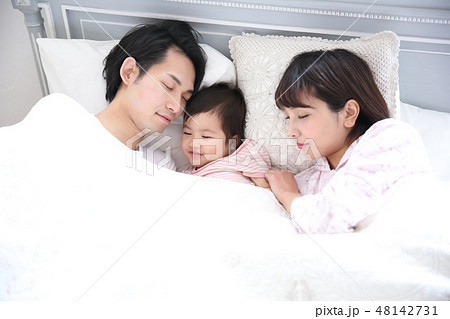 ベッドに入る若い家族 48142731