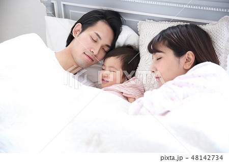 ベッドに入る若い家族 48142734