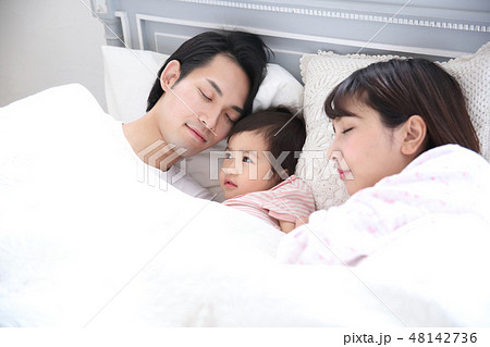ベッドに入る若い家族 48142736